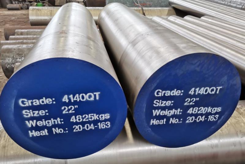 Stacked round steel bars with dark mill surfaces and painted ends