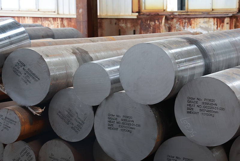 Warehouse stack of large round steel bars with coloured end faces