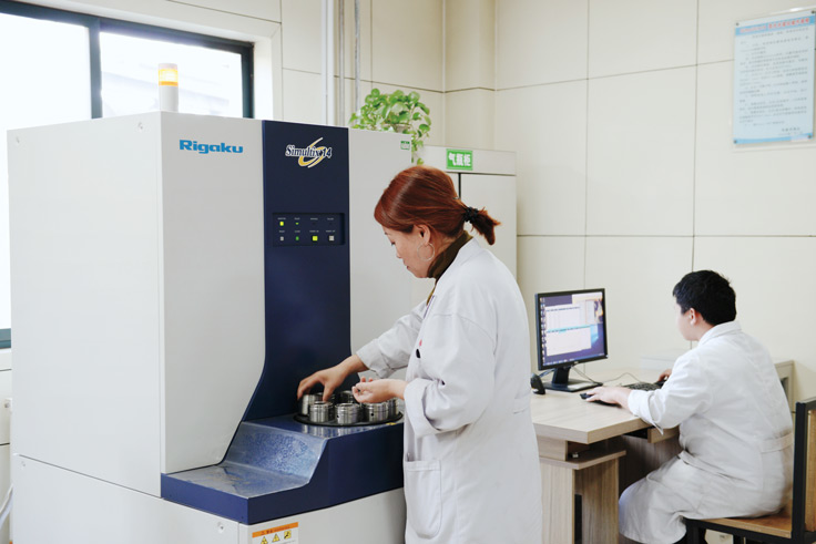 Technician operating a multi-element laboratory analyzer.