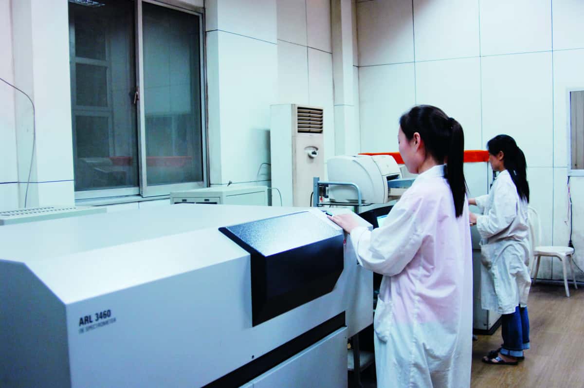 Technician operating an optical emission spectrometer.